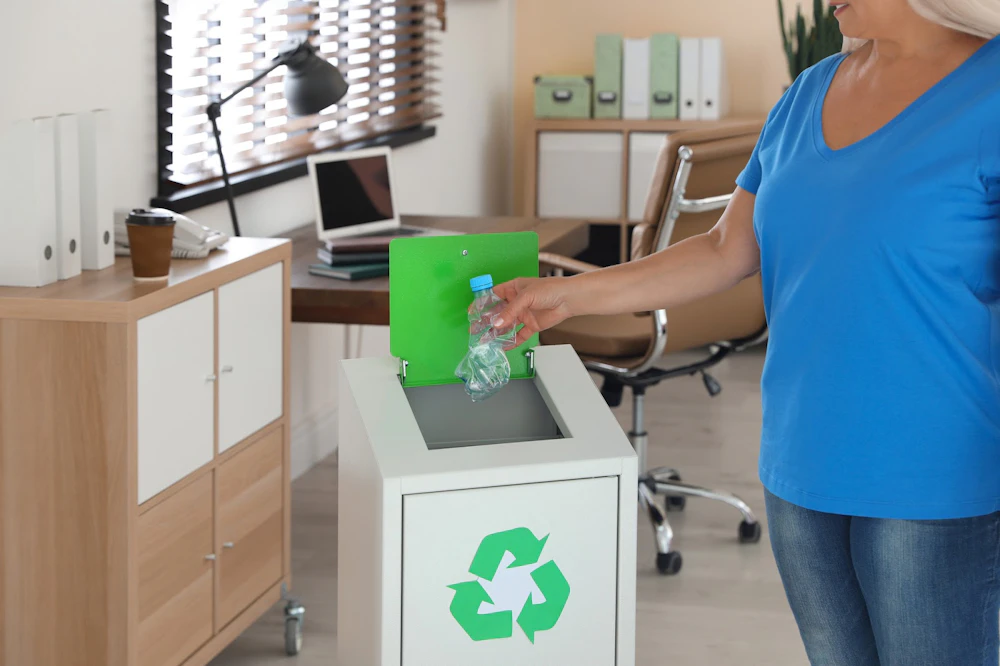 Woman recycling a water bottle Why Green Cleaning and Recycling Is a Great Message to Send Your Employees