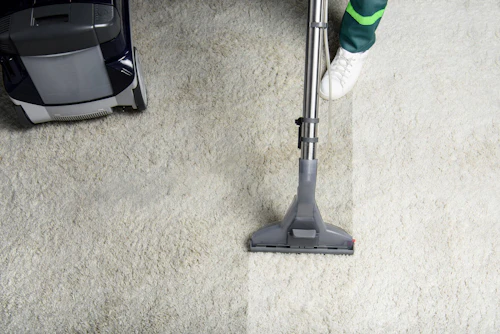 Carpet cleaner cleaning a white commercial carpet