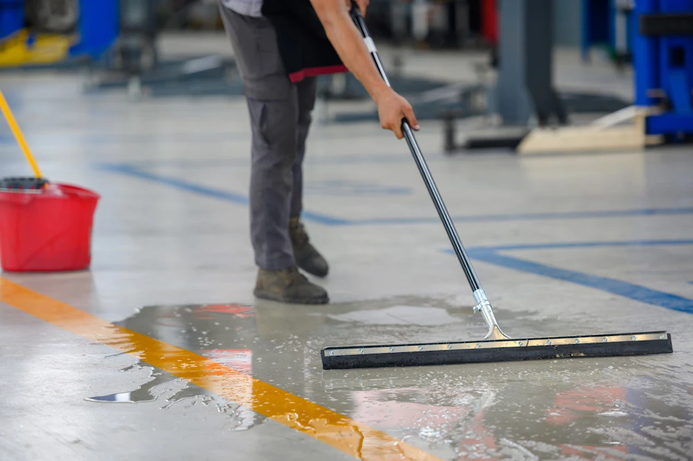 Man cleaning a warehouse floor Top 5 Floor Care Tips for Your Warehouse in the Spring
